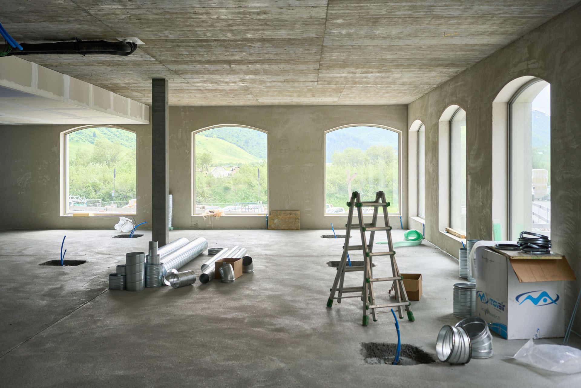 A large room with windows and a ladder